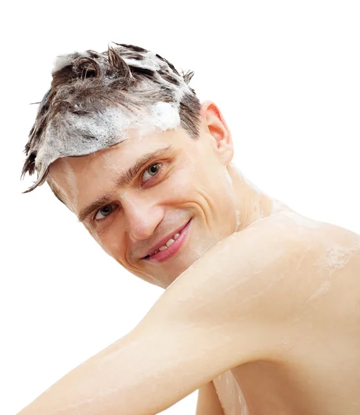 Man with shampoo over hair in shower isolated on white background. — Stock Photo, Image