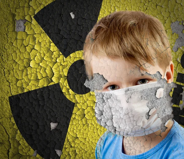 Мальчик в маске над старым знаком радиации на бетонной станции гранжа. — стоковое фото