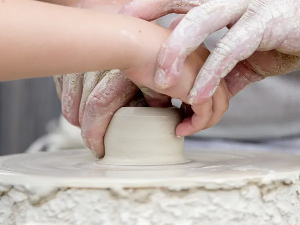 Artisan learning a child to make potter from white clay. — Stock Photo, Image