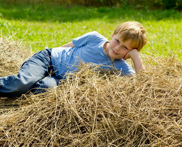 Jongen hebben een rust op de hooiberg. — Stockfoto