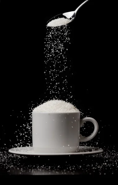 Sugarfall. šálek kávy s kopce cukru a lžíci. koncepce přidat — Stock fotografie