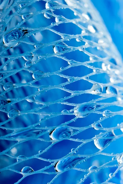 Αφηρημένη μακρο φωτογραφία του μασάζ μπλε σφουγγάρι μπάνιο με σταγόνες νερό. — Φωτογραφία Αρχείου