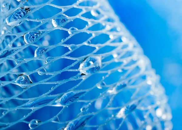Abstrakt makro foto av massage blå bad svamp med vattendroppar. — Stockfoto
