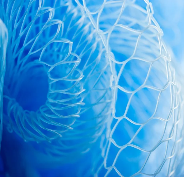 Foto macro abstrata da esponja de banho azul de massagem com gotas de água . — Fotografia de Stock