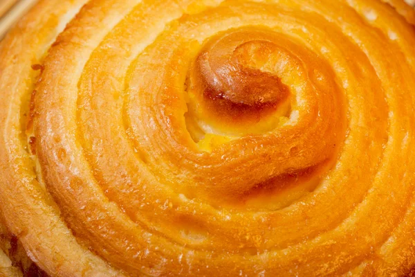Delicious buns with fun curls, covered sweet glaze. Macro. — Stock Photo, Image