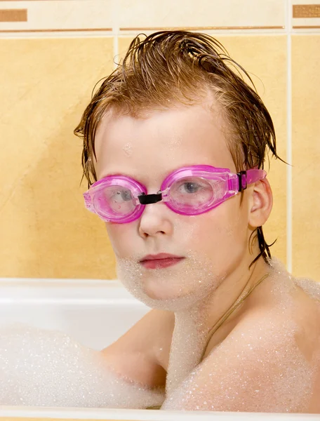 Ładny chłopak bawić się w łazience. chłopiec w pianki kąpieli i pływania iść — Zdjęcie stockowe