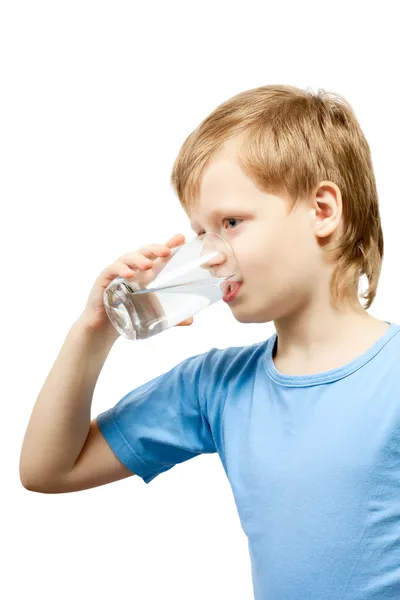 Liten pojke dricka kallt vatten på glaset. Stockfoto