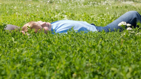 少年は、緑の草に楽しい時を過す. ストック写真