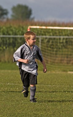 Çocuk futbol oynuyor.