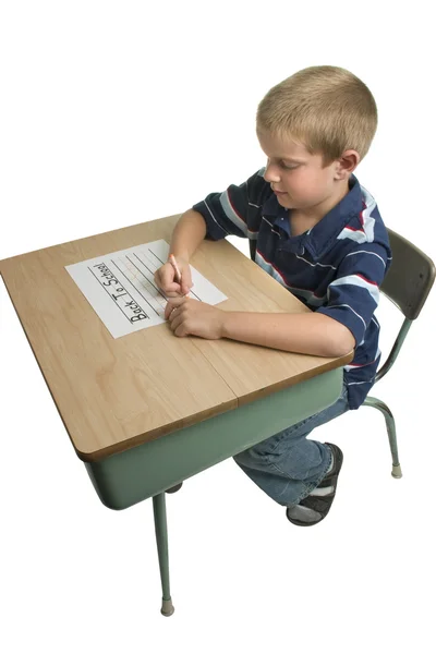 Menino escrevendo na mesa da escola — Fotografia de Stock