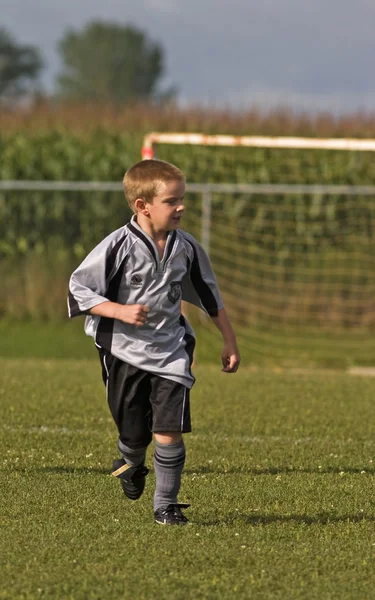 Pojke spelar fotboll Royaltyfria Stockfoton