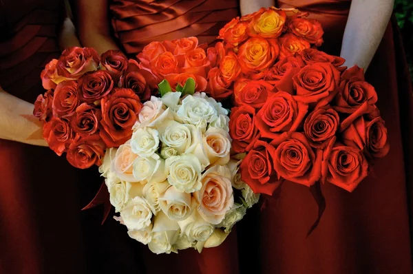 A close up image of a bride and her bridesmaid holding bridal bouquets — Stock Photo, Image