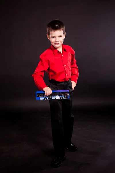 Junge im offiziellen Dresscode mit Spielzeugbus — Stockfoto