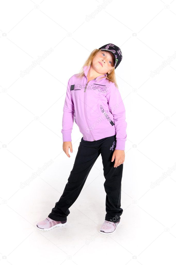 Young girl in sport outfit and a baseball hat posing in studio on white