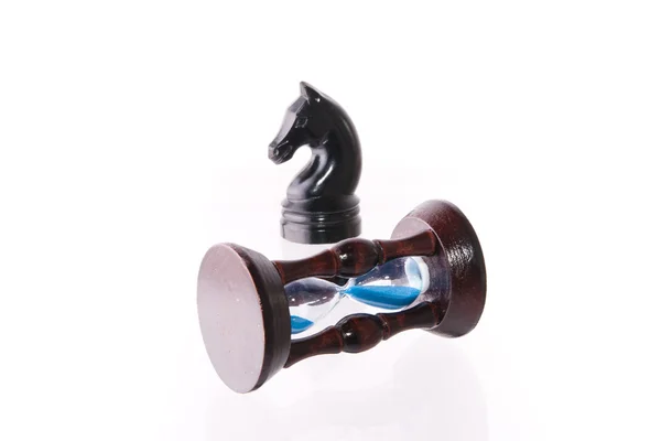 Черная шахматная лошадь с песчаными часами — стоковое фото