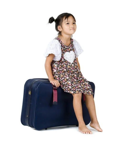 Menina bonito sentado na bagagem — Fotografia de Stock