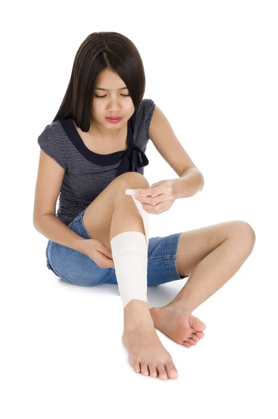 Woman wrapping a bandage around her leg — Stock Photo, Image