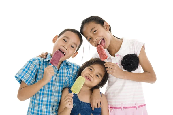 Братья и сёстры едят мороженое — стоковое фото