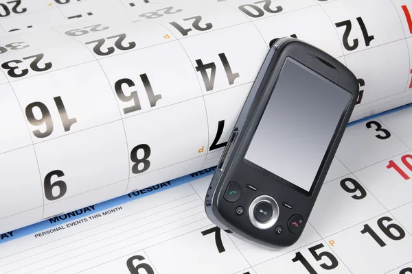 Telefone inteligente no calendário — Fotografia de Stock