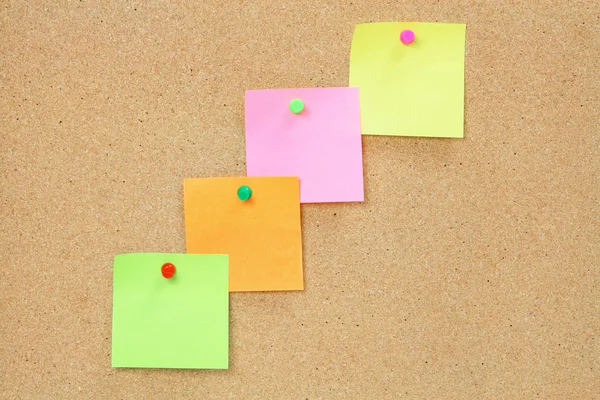 Adhesive Note Papers on Cork Board