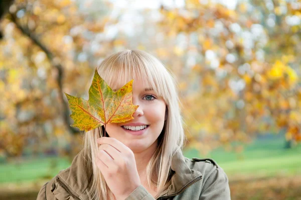 Ung kvinna med höstens löv — Stockfoto