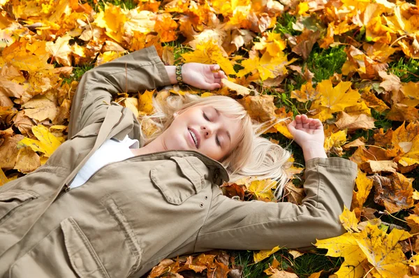 Jovem mulher sonha em folhas de outono — Fotografia de Stock