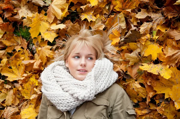 Fiatal nő feküdt az őszi levelek — Stock Fotó