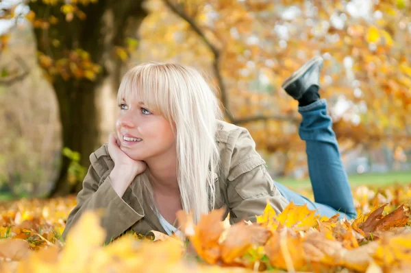 秋の紅葉で横になっている若い女性 — ストック写真