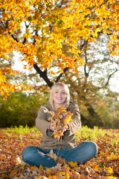Mladá žena s podzimní listí — Stock fotografie