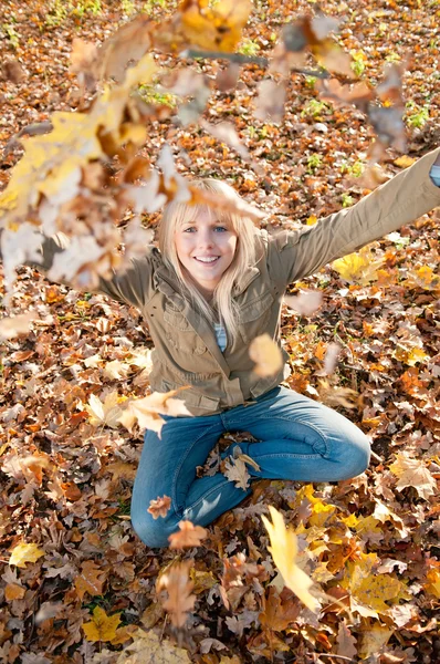 Jonge vrouw spelen met Herfstbladeren — Stockfoto
