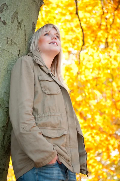Νεαρή γυναίκα να στέκεται σε ένα δέντρο — Φωτογραφία Αρχείου