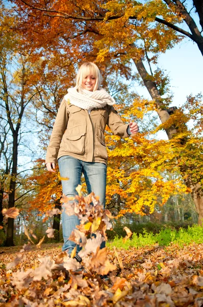 Femme jouant avec les feuilles d'automne — Photo