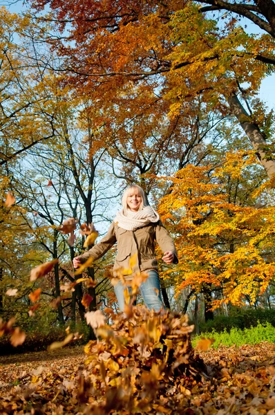 秋天的树叶玩的女人 — 图库照片