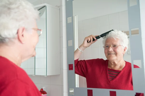 Бабушка расчесывает волосы. — стоковое фото