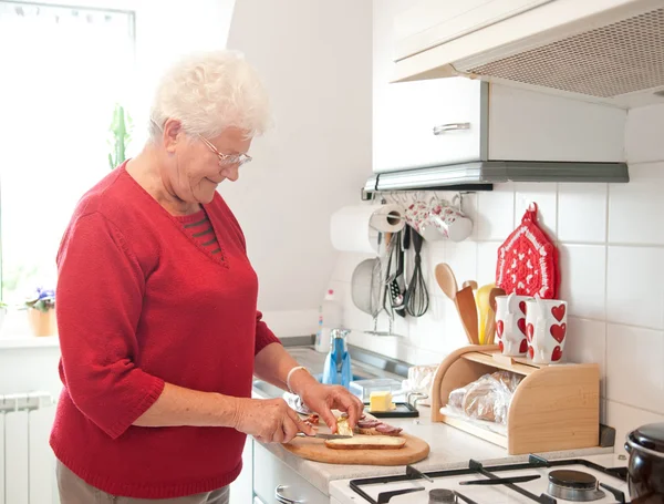 Gammal kvinna i köket — Stockfoto