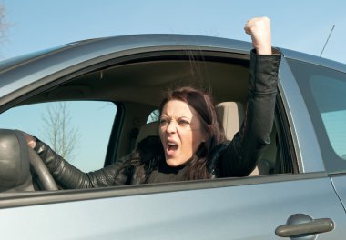 Woman in the car shows the fist clipart