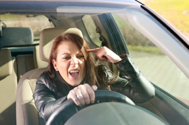 Angry woman gesturing in the car clipart