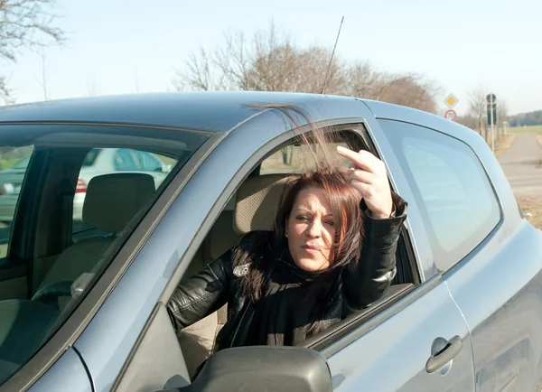 Kobieta w samochodzie pokazuje środkowy palec — Zdjęcie stockowe