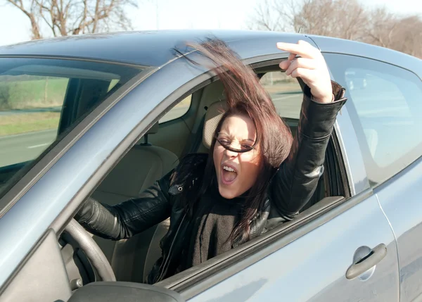 Kobieta w samochodzie pokazuje środkowy palec — Zdjęcie stockowe