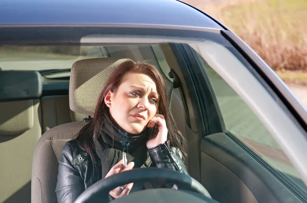 Mulher com cigarro e celular no carro — Fotografia de Stock