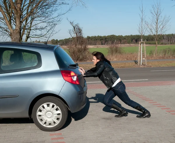 stock image Woman pushes her car