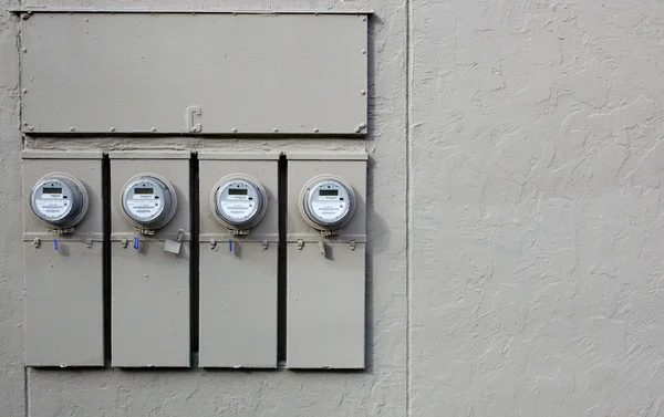 Cuatro medidores eléctricos pared gris — Foto de Stock