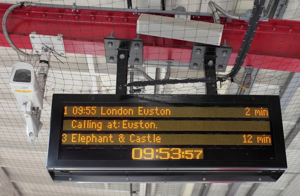 stock image Electronic Timetable on London Railway Platform with Security Ca