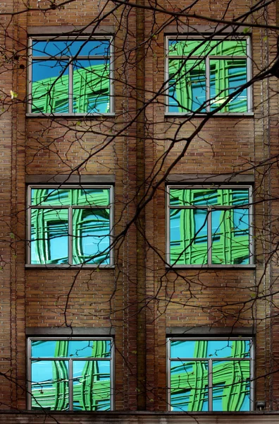 Αντανάκλαση της πολύχρωμα κτίριο στα παράθυρα των παλαιών μπλοκ — Φωτογραφία Αρχείου