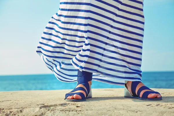 Weibliche Füße im wogenden Kleid — Stockfoto