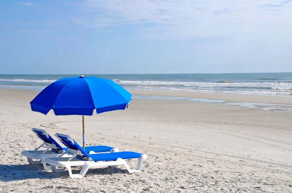 Cadeiras de praia com guarda-chuva azul — Fotografia de Stock