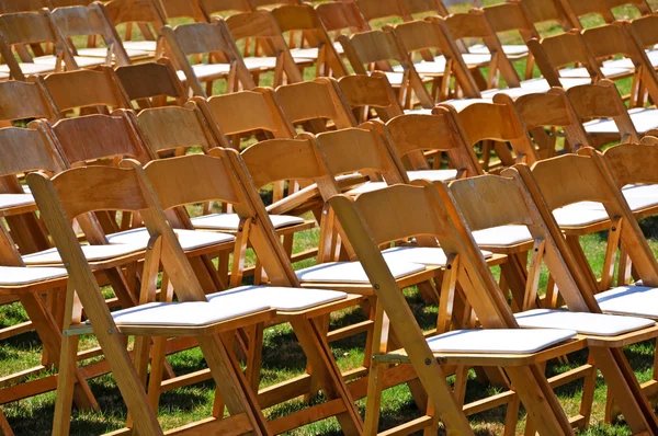 Rows of wooden chairs on lawn — Stock Photo, Image