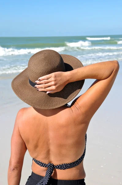 Mulher atraente em pé na praia — Fotografia de Stock