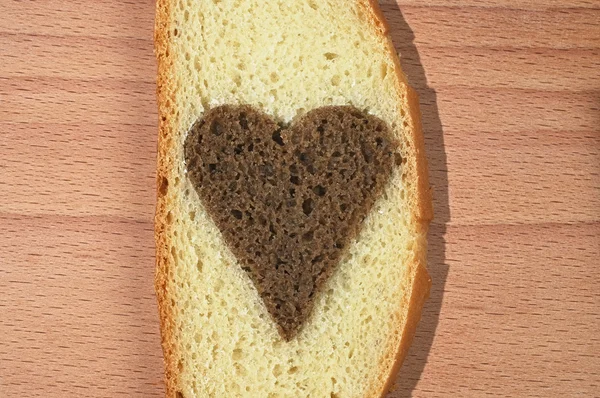 cut out kahverengi ekmek kalp ile beyaz bir ekmek parçası