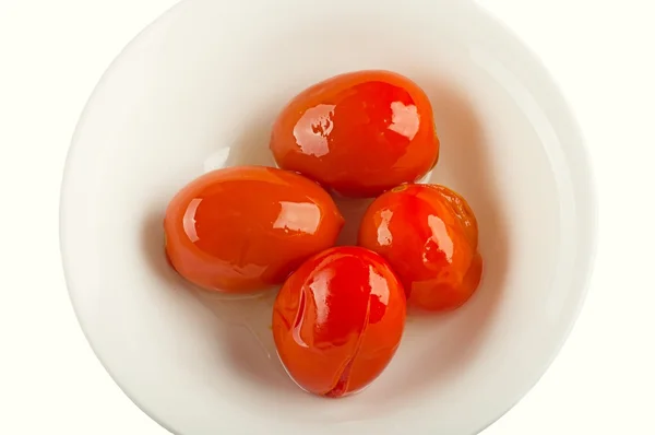 Четыре маринованных помидора на белой тарелке — стоковое фото